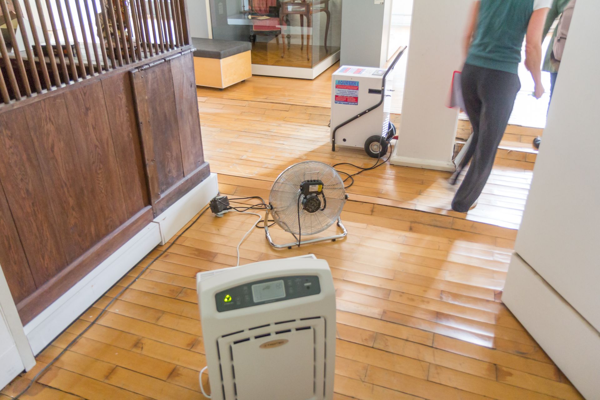 Dehumidification equipment beside water-damaged parquet flooring