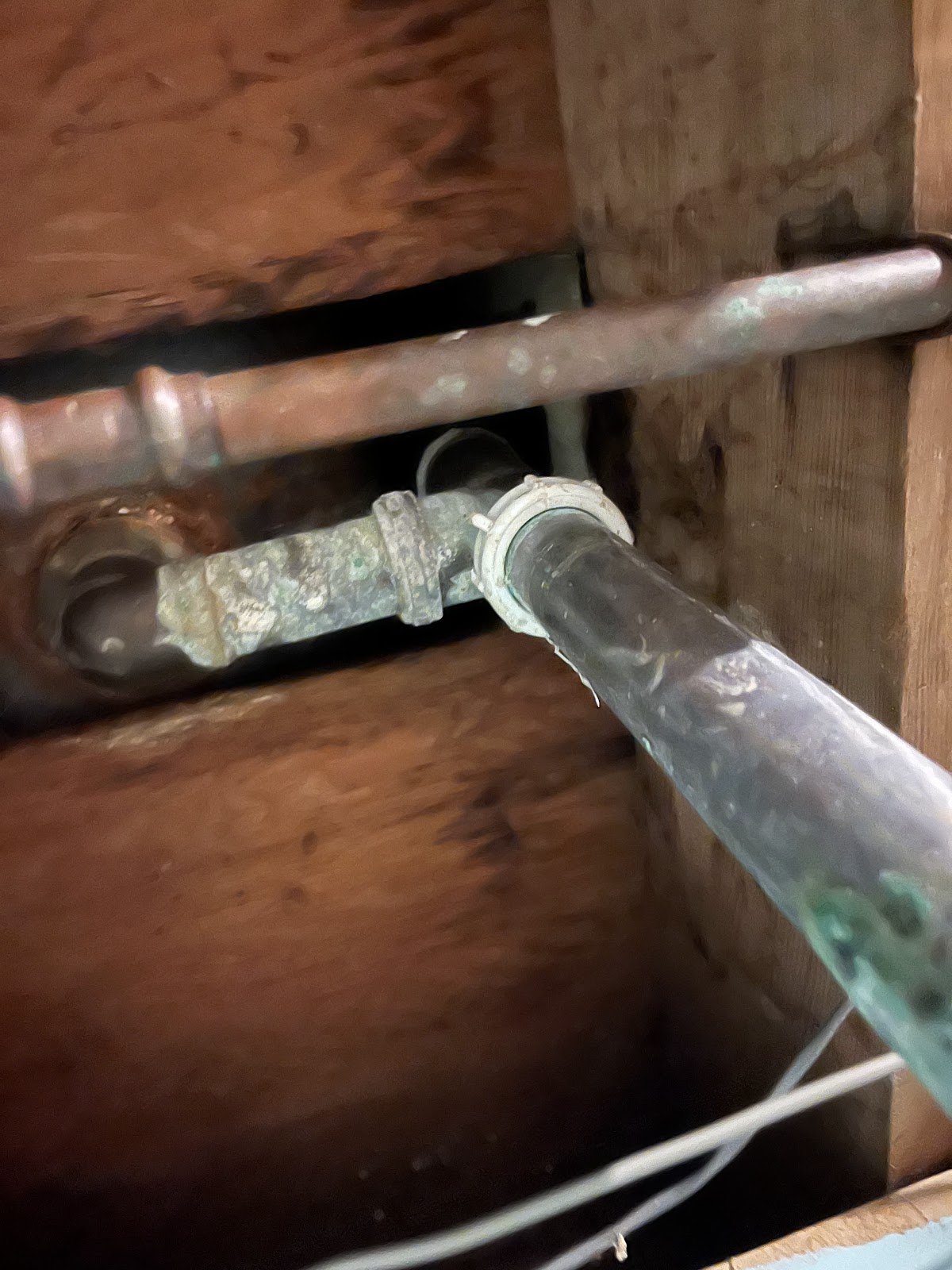 Corrosion and a damaged connection on an exposed copper pipe
